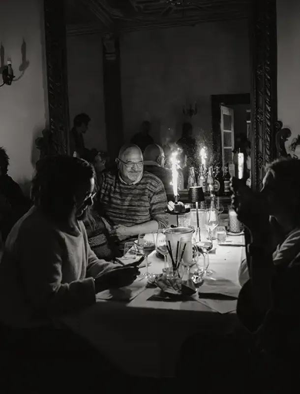 Gruppe an Personen sitzt am Tisch, Eventbild in schwarz weiß