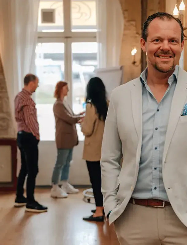 Mann lächelt auf Röstburg Event im Anzug