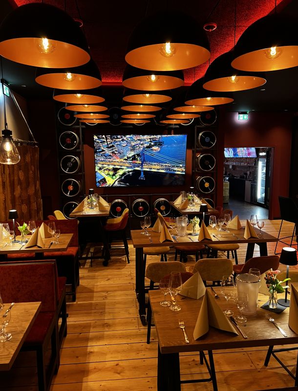 Stimmungsvolles Bild mit warmen Licht und gedeckten Tischen der Röstburg Bar