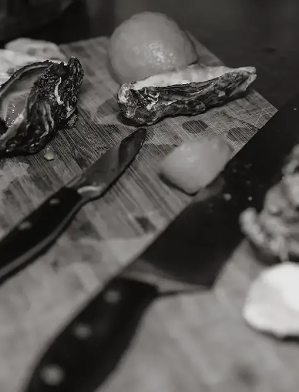 Austern mit Messer auf Holzbrett, schwarzweißbild